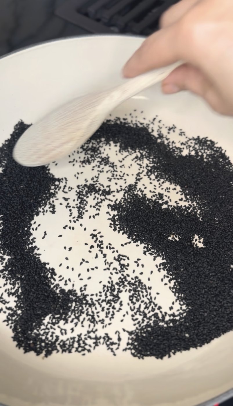 black seeds toasting in a pan