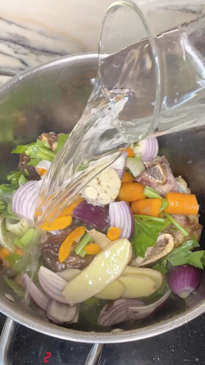 water poured over the bones and vegetables until everything is covered
